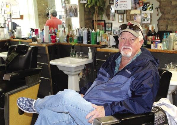 Jeff Hullum, son of the late Tom Hullman, took a break while he remembered fondly the Hullum’s Barber Shop his father owned and operated for decades. Hullum associate barber Dixie Harrison (in the mirror) gazed sadly through the shop’s front window. Raymond V. Whelan/Bulletin