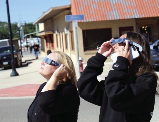 (Left) Burnet resident Mandy Stees and her daughter Caera peer through special sunglasses to see the partial eclipse during the Annular Eclipse Party Oct. 14 in Burnet at the Herman Brown Free Library.