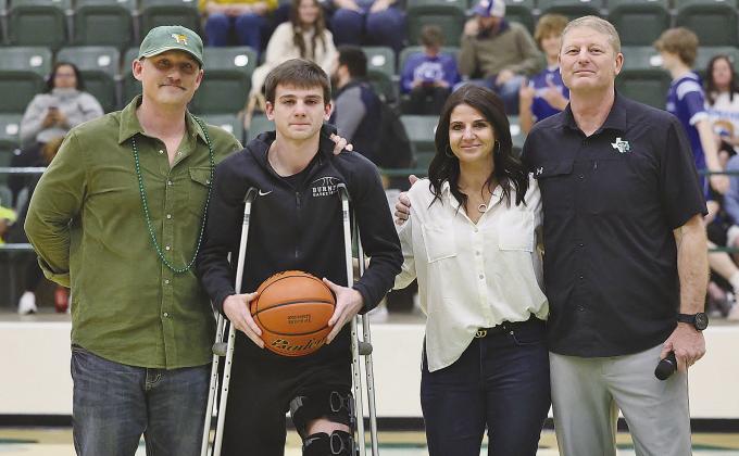 Only five players in Burnet’s history have scored 1,400 career points and Baylor Dawes was honored as one of them after logging 1,442 career points in three years. The mark puts him at fifth all time. Standing with Baylor are his parents Marcus and Amber as well as head coach Roy Kiser. Photo by Wayne Craig/Clear Memories
