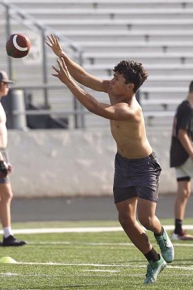 Incoming freshman, Alex Perez pulls in a pass during drills. This year’s summer workout program has been a huge success with large participation.
