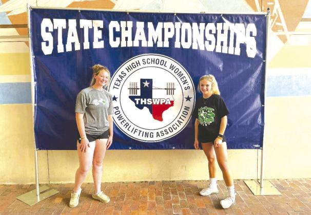 Burnet sophomore, Abby Smith (right) stands with teammate Emmalee Williams in front of the UIL State banner. Smith made her second trip to the state powerlifting meet in 2022 taking 14 place in the 114s with a 660 total.