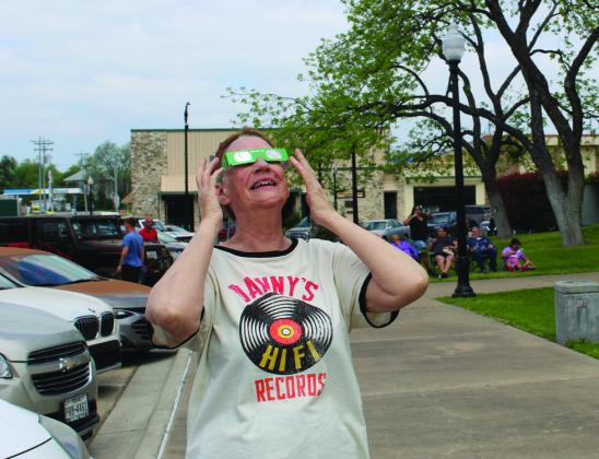 Burnet resident Barbara Randle peered up at the sun nearly swallowed by gray clouds and increased darkness several minutes before the total solar eclipse April 8 in Burnet at the county courthouse. Raymond V. Whelan/Bulletin