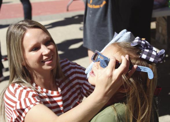 Lampasas resident Jennifer Gibbs helps her daughter Collyns adjust her special sunglasses for the Annular Eclipse Party Oct. 14 in Burnet at the Herman Brown Free Library. Raymond V. Whelan/Bulletin