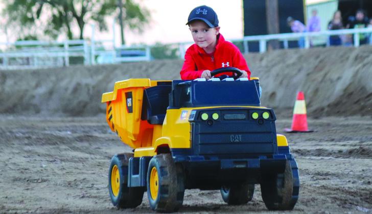 At left, winner Caden Conway in Cat dump truck makes his way to the finish line winning by a large margin Saturday, Oct. 14 during the Hot Wheels Race.