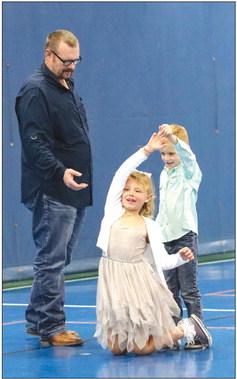 Chandler Gage knelt to facilitate her brother, Chandler Gage’s spin at the DIVA Dawgs and Bulldog BROS Family Dance and Dodgeball held at the YMCA Feb. 18 while dad Robby Gage offered a hand up.