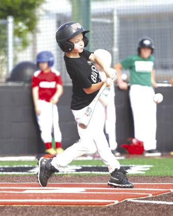 Baze Benton turns on a pitch and makes contact for a hit during youth baseball camp last week. Different sports camps will run at the high school over the next two weeks.