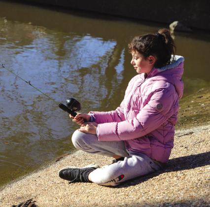 Maddie Surasky, 11, patiently waited for her first bite Dec. 28, beside Hamilton Creek at the Texas Parks and Wildlife Department rainbow trout release.