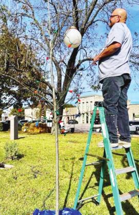 Contributed/Judge James Oakley County maintenance worker Charles Brown adorned the Burnet County “Charlie Brown Christmas Tree” with ornaments on Nov. 23. This year’s decorations are scheduled to be illuminated through Jan. 1.