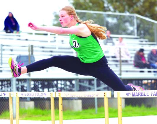 Wrigley Mulhollan flies over the hurdle during the varsity girls 100 meter hurdle competition in Marble Falls.