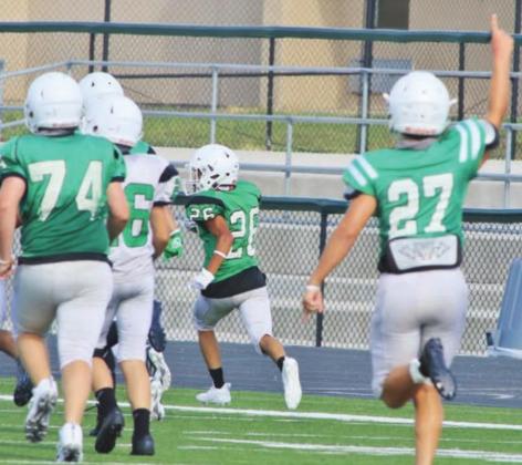 Bulldog receiver, Trenton Park (11), collects a pass at the line of scrimmage and quickly sheds a tackler before racing 36-yards for an early score at Saturday’s scrimmage in Burnet.