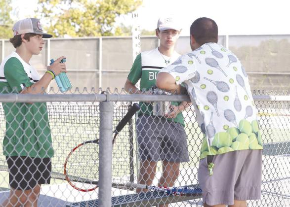 Between sets Burnet head tennis coach Nathan Redman gives some pointers to doubles players Luke Suchomel and Nick Dietrich.